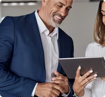 Two professionals collaborating while looking at a digital tablet in a modern office.