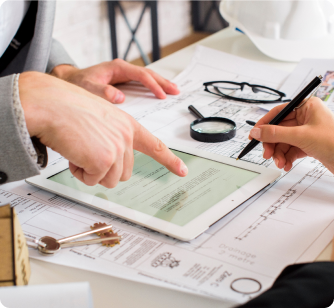 Two people pointing at printed financial data and colorful charts next to a calculator.