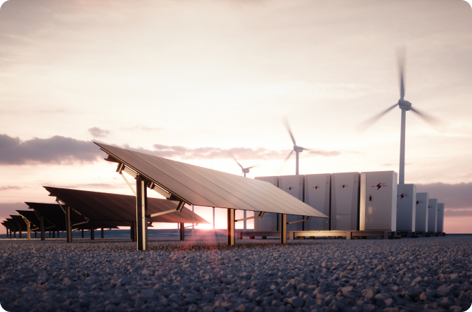A wide shot of a renewable energy field at sunset featuring rows of solar panels, large battery storage units, and wind turbines in the distance.